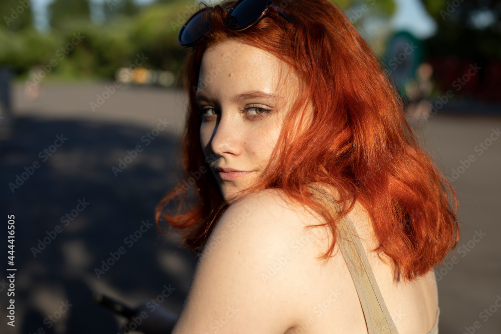 Fototapeta premium The girl looks dreamy. Red-haired beauty. Teenager in t-shirt.