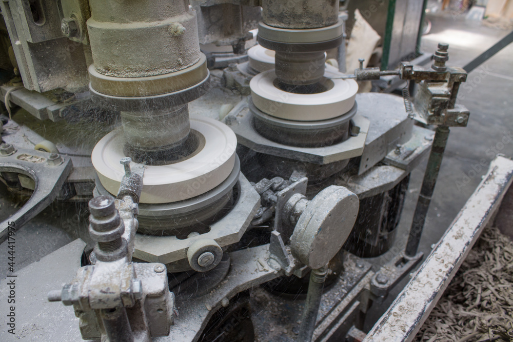 Metal rotating machine for making ceramic tableware from clay tableware close-up at a porcelain factory in Moscow region Metal rotating machine for making ceramic tableware from clay tableware close-up at a porcelain factory in Moscow region
