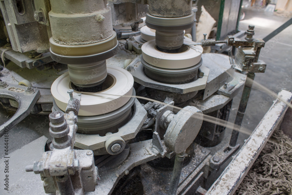 Metal rotating machine for making ceramic tableware from clay tableware close-up at a porcelain factory Metal rotating machine for making ceramic tableware from clay tableware close-up at a porcelain factory
