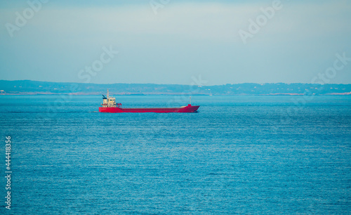 Large commercial cargo ship sailing through a channel. 