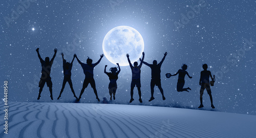 Group of friends jumping on top of dune with arms raised in air with full blue moon "Elements of this image furnished by NASA "