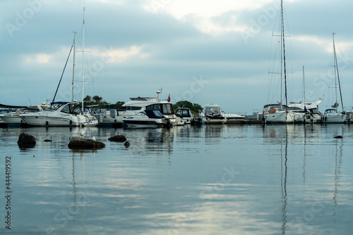 Marina with sailboats and power boats docking during a summers evening.