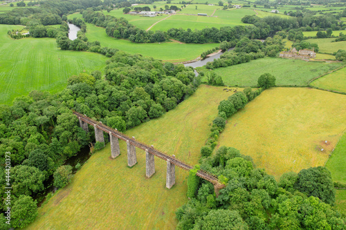 Aerial view of an old bridge with Bridgetown Abbey in the background, a 13th-century Augustinian monastery of the Canons Regular of St. Victor in Castletownroche, County Cork, Ireland