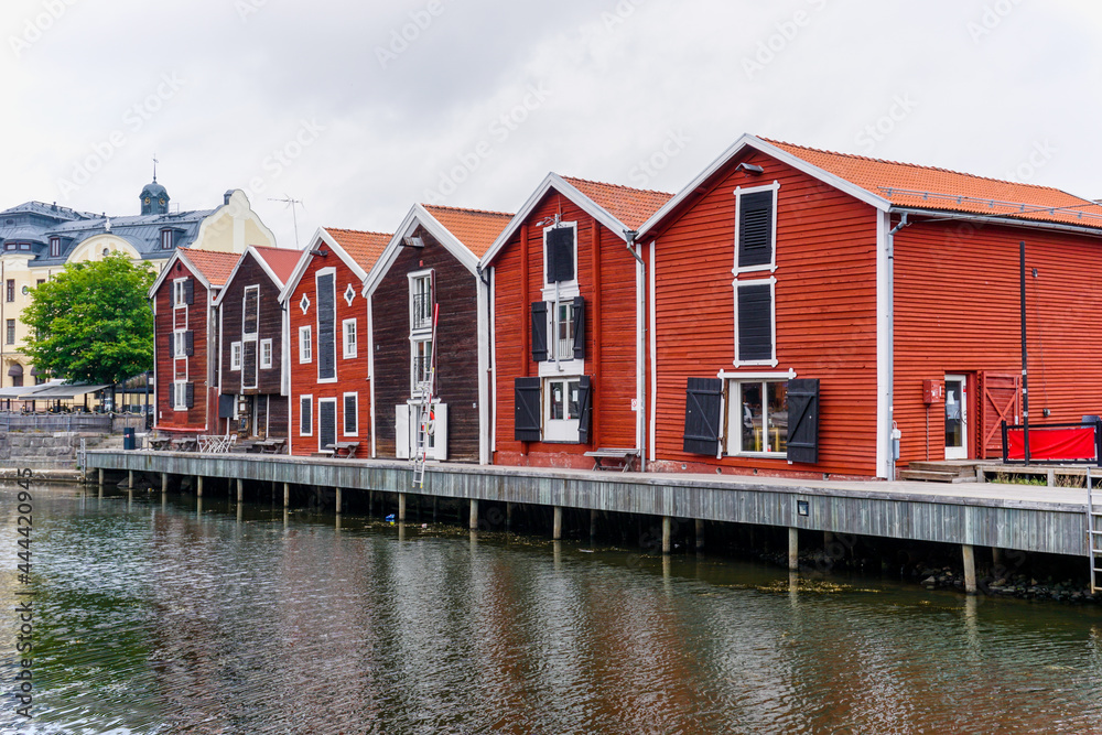 red and brown wooden warehouses along the waterfront in Hudiksvall