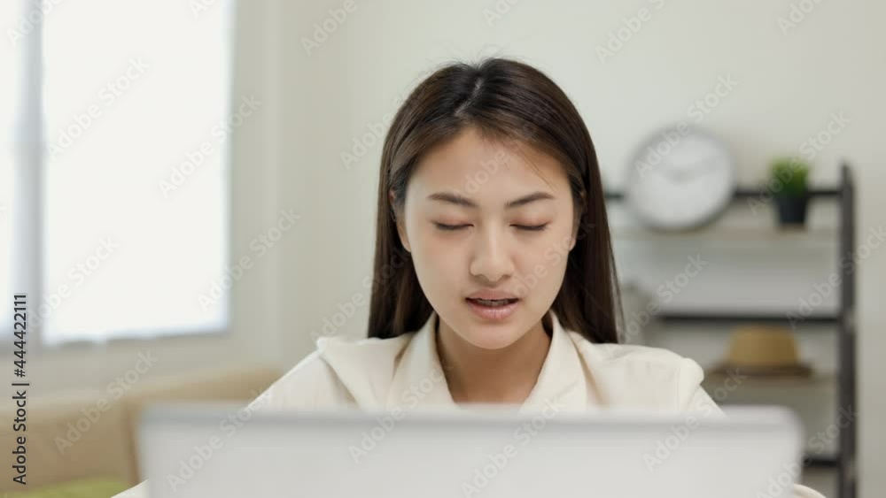 Young asian woman using laptop chatting video conference online sitting in living room at home. Business Woman looking at screen Meeting on social media live steam. Work, learning from home. Young asian woman using laptop chatting video conference online sitting in living room at home. Business Woman looking at screen Meeting on social media live steam. Work, learning from home.