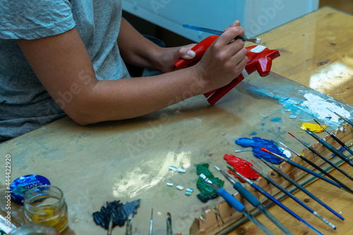 female artisan painting traditional Swedish Dala horses in a a workshop photo