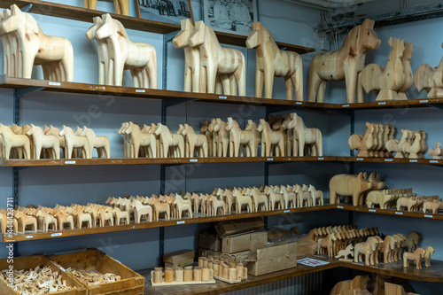 shelves of unpainted wooden Swedish Dala horses in a woodworking workshop photo