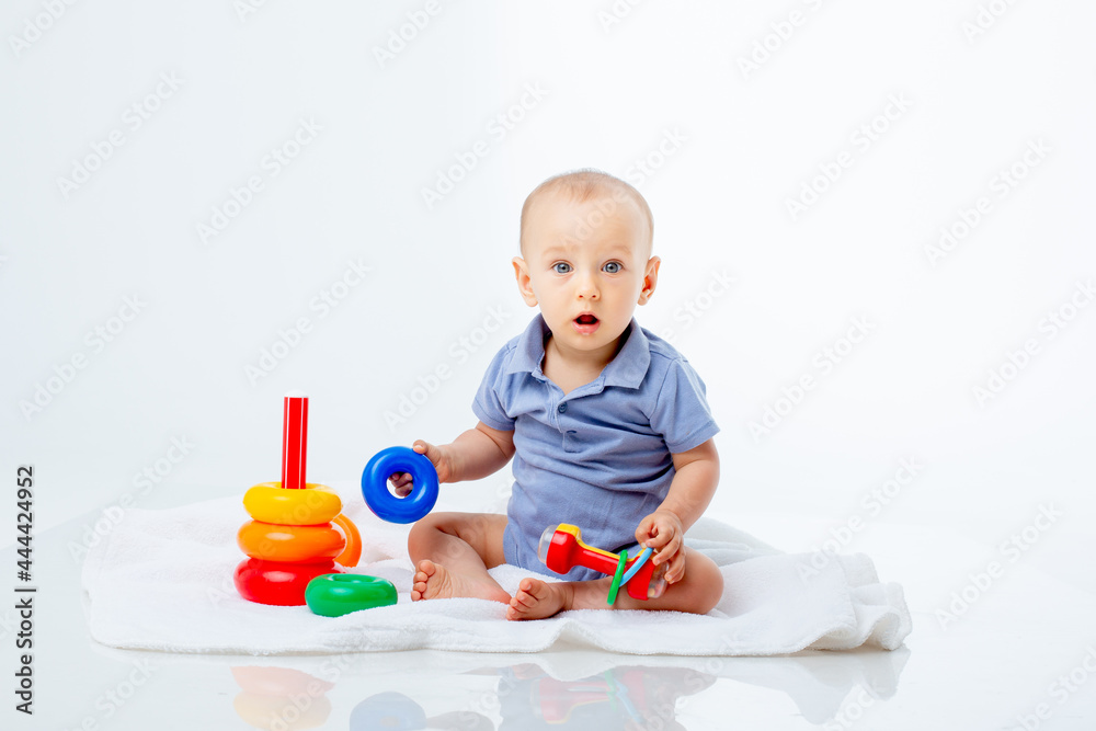 baby boy with a multi-colored pyramid is isolated on a white background; baby boy with a multi-colored pyramid is isolated on a white background;
