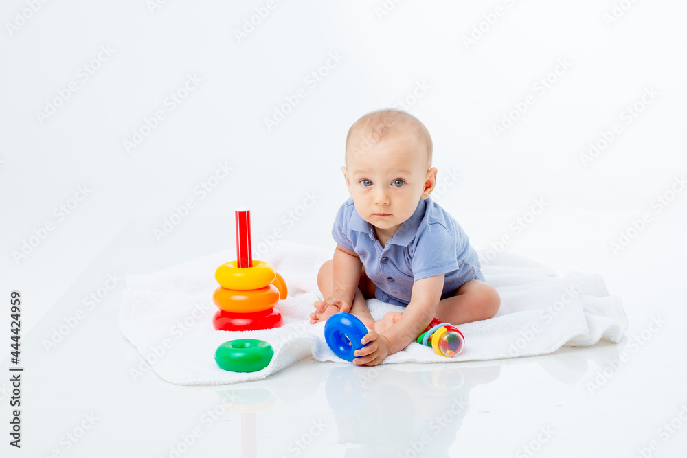 baby boy with a multi-colored pyramid is isolated on a white background; baby boy with a multi-colored pyramid is isolated on a white background;