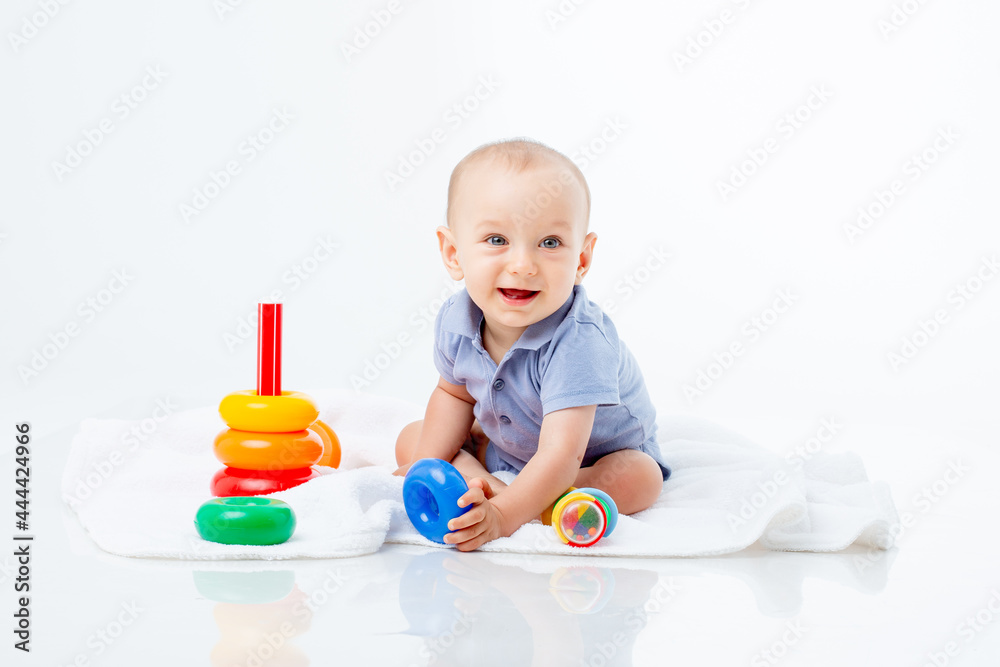 baby boy with a multi-colored pyramid is isolated on a white background; baby boy with a multi-colored pyramid is isolated on a white background;