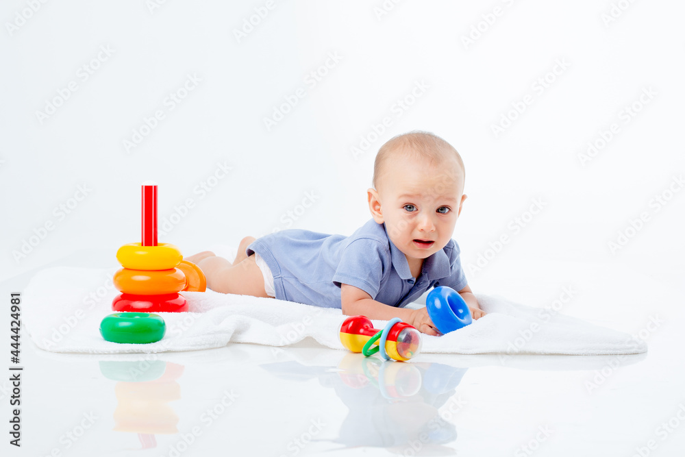 baby boy with a multi-colored pyramid is isolated on a white background; baby boy with a multi-colored pyramid is isolated on a white background;