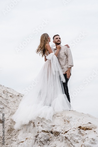 Beautiful wedding couple bride and groom at wedding day outdoors at ocean beach. Happy marriage couple o