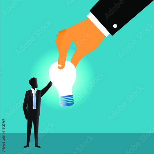 the light bulb is held by the businessman and the hand