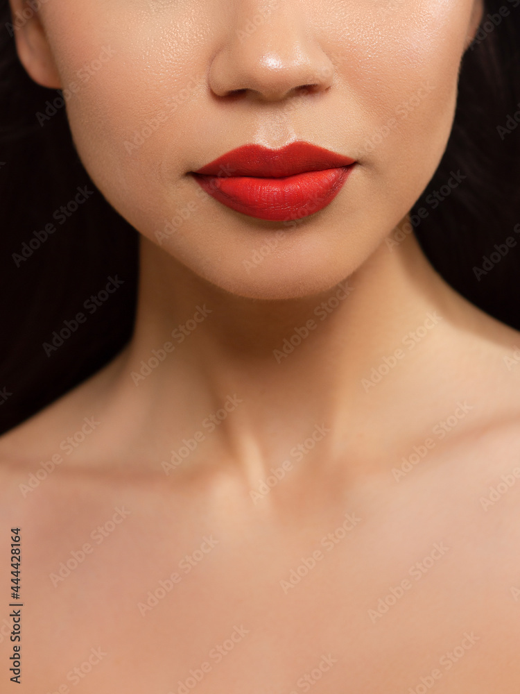 Cosmetics, makeup and trends. Bright lip gloss and lipstick on lips. Closeup of beautiful female mouth with natural lip makeup. Beautiful part of female face. Perfect clean skin in red light Cosmetics, makeup and trends. Bright lip gloss and lipstick on lips. Closeup of beautiful female mouth with natural lip makeup. Beautiful part of female face. Perfect clean skin in red light