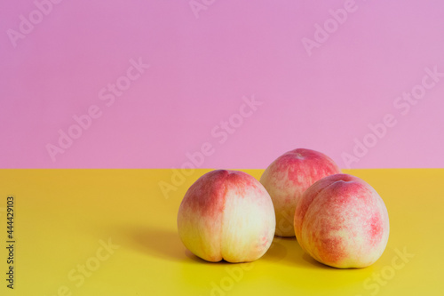 3個の桃　黄色とピンクの背景