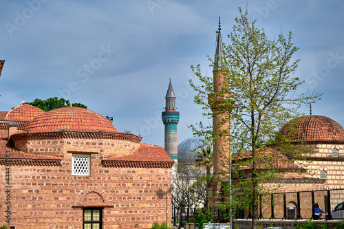 Nicaea (iznik), Bursa Turkey.  seyh  kutbuddin and its son tomb made of red bricks wall with its minaret extends to blue cloudy sky with green mosque (yesil cami) background. 17.04.2021. iznik turkey. photo