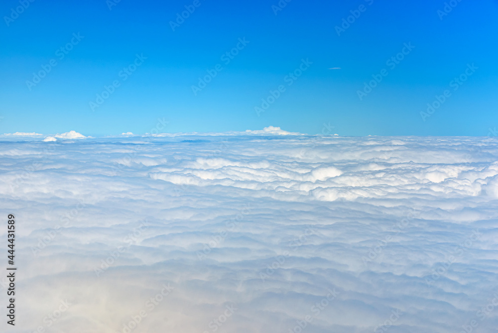 Naklejka premium Clouds against blue sky view through an airplane window for a background.