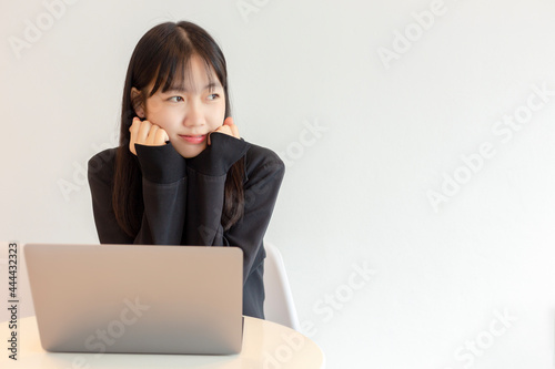 Young asian woman using laptop in white background. Beautiful asian woman working from home. selective focus on a woman.
