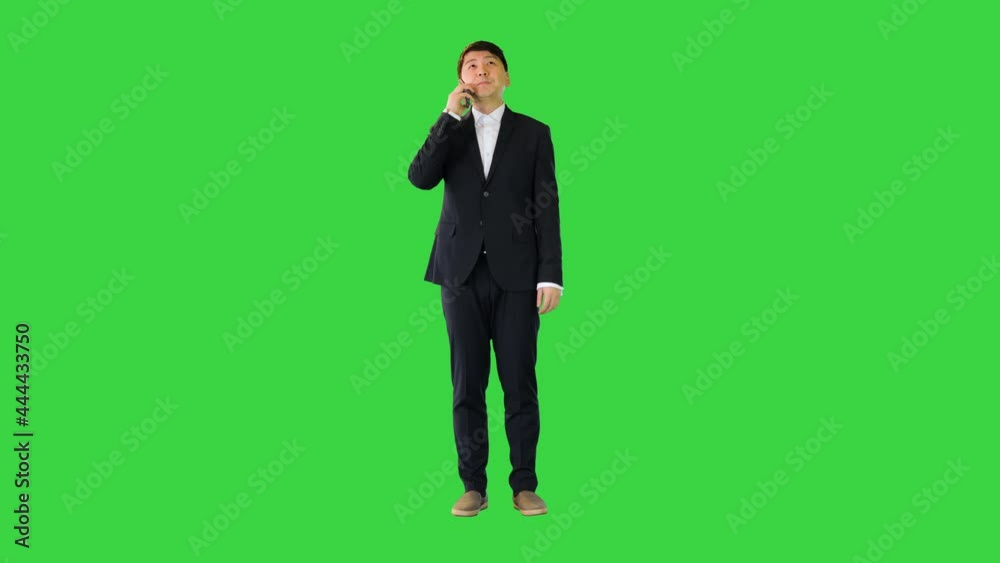 Asian man in office suit talking on mobile phone on a Green Screen, Chroma Key. Asian man in office suit talking on mobile phone on a Green Screen, Chroma Key.