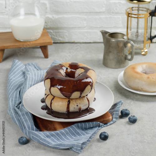 Donuts with chocolate topping on table with milk