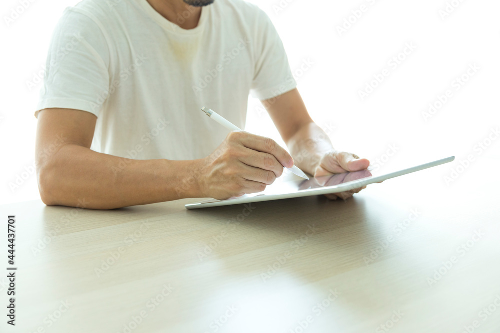 Obraz premium Young man using tablet with blank screen on table at coffee shop or home office.