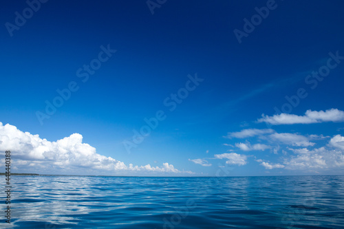 Fototapeta Naklejka Na Ścianę i Meble -  clouds on blue sky over calm sea with sunlight reflection