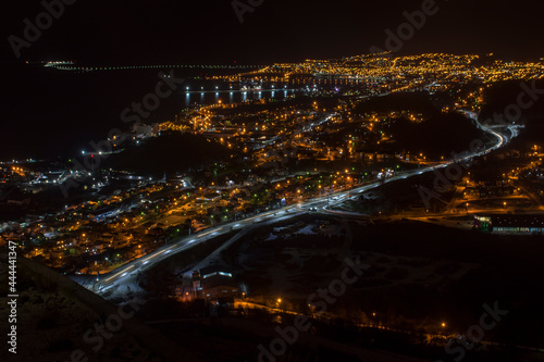 Panoramic night view of Ushuaia city, Tierra del Fuego, Argentina. Lights on the pu-left corner are from the road to the airport.