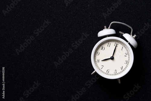 Retro alarm clock on black table background, vintage style