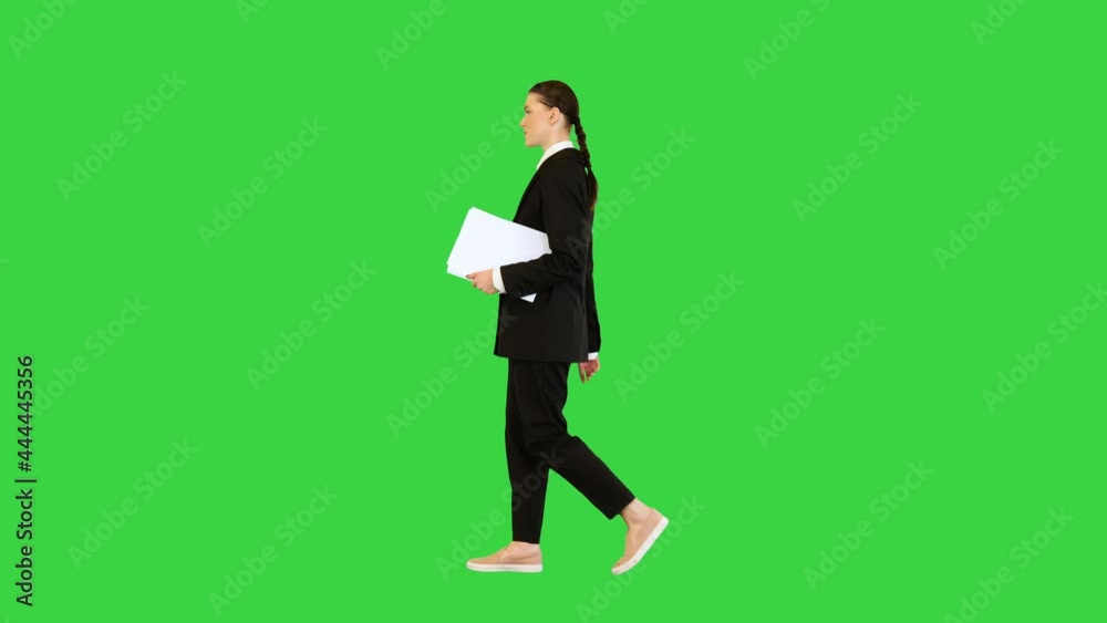 Woman in office suit walks with documents in her hands on a Green Screen, Chroma Key. Woman in office suit walks with documents in her hands on a Green Screen, Chroma Key.