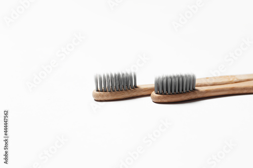 Close-up of two bamboo toothbrushes on white background.