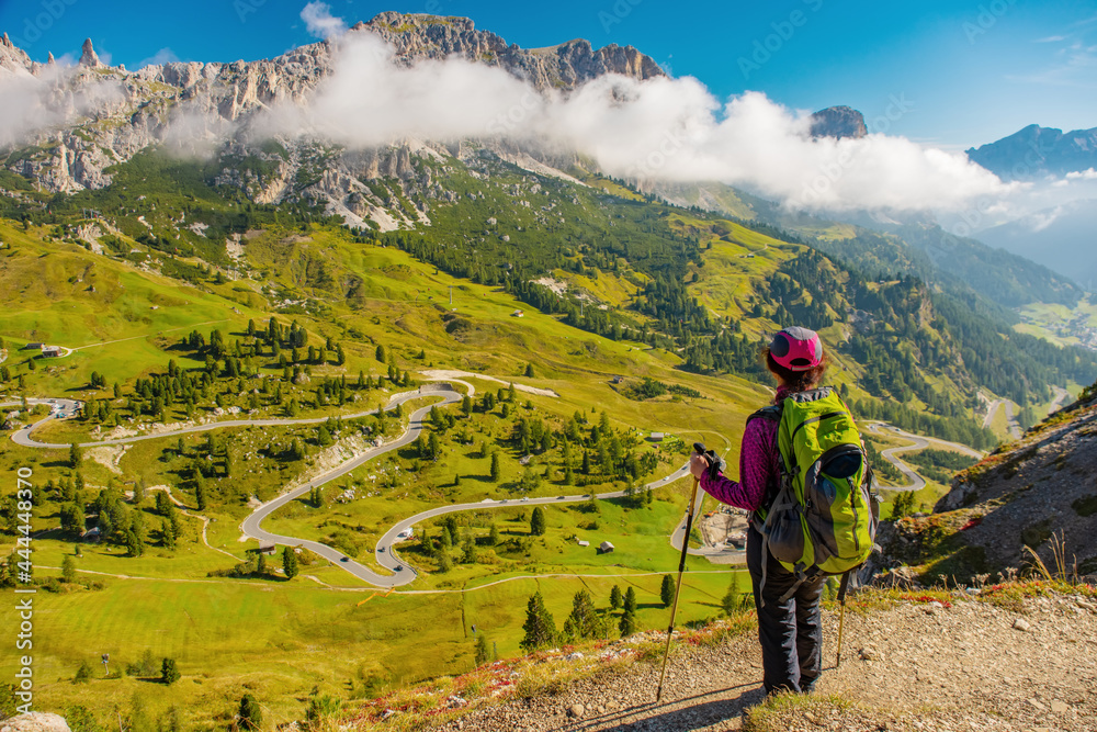 Active hiker hiking, enjoying the view, looking at Dolomites mountains landscape