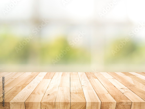 Empty wood table top on blur abstract green garden from window view in the morning