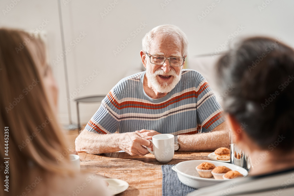 Senior man laughing out loud while speaking with his friends at the retirement house Senior man laughing out loud while speaking with his friends at the retirement house