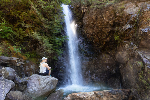 Adult Woman hiker at Norvan Falls and river stream in the natural canyon during the summer time. Canadian Nature Background. Lynn Valley, North Vancouver, British Columbia, Canada.