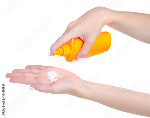 Suntan lotion cream bottle in hand on white background isolation