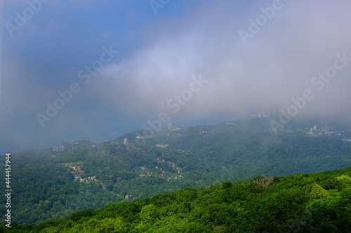 View of mountains and forest in the fog mist, landscape of mountain Akhun hills with radio towers and a Ferris wheel in the morning haze with noise film grain effect, soft selective focus