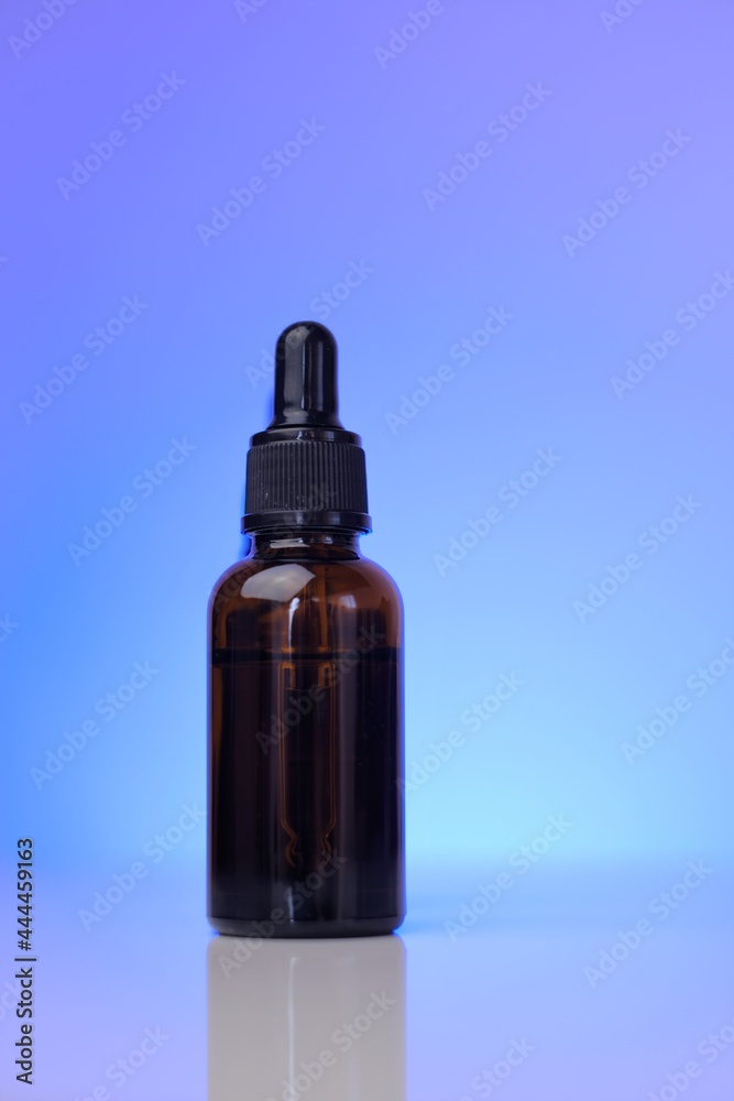 Organic oils. Serum for face skin. Natural bio cosmetics concept.Two glass brown bottles on a blue background.Cosmetic Mockup . Face serums in brown glass bottles in blue light.copy space. Organic oils. Serum for face skin. Natural bio cosmetics concept.Two glass brown bottles on a blue background.Cosmetic Mockup . Face serums in brown glass bottles in blue light.copy space.