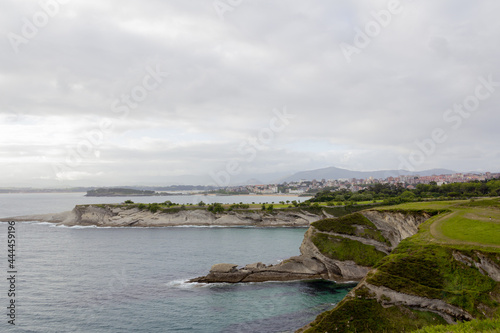 Sunset on a cliff facing the sea on a cloudy day with the city of Santander (Spain) in the background. Selective focus. Copy space.