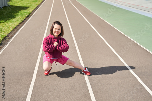 Midget woman doing stretching at the stadium at the morning photo