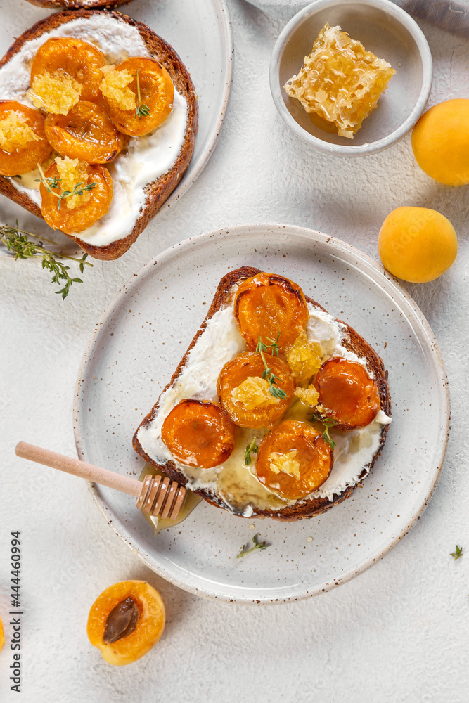 bruschetta with baked apricot, cottage cheese, thyme and honey. on white background. atmosphere of morning and breakfast