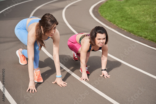 Sporty girls are ready to run on the racetrack at the stadium