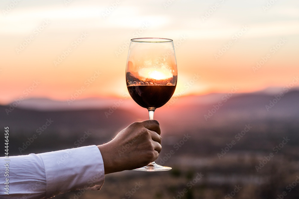 Copa de vino tras el sol en la montaña