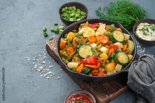 Foto Frying pan with vegetable stew on a gray-blue background.