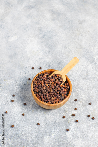 Black peppercones in a small bowl and jar. photo