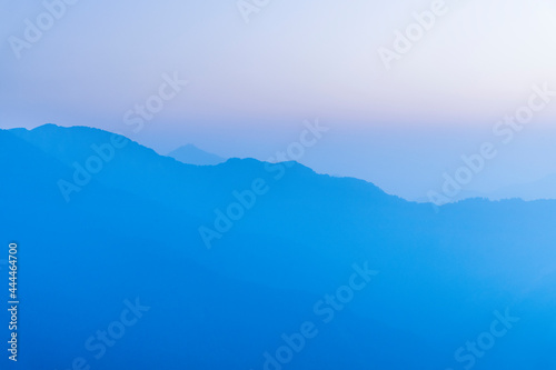 Layers of magnificent mountains with colorful clouds background the sunrise view