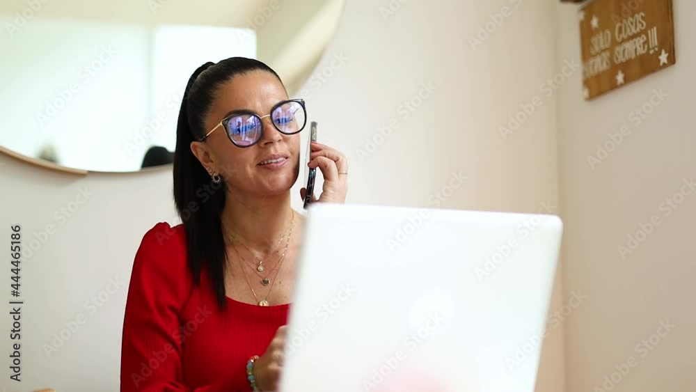 mujer latina senatada en la mesa de su hogar, haciendo negocios desde su laptop