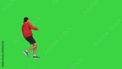 Sporty man in a cap running by on a Green Screen, Chroma Key.