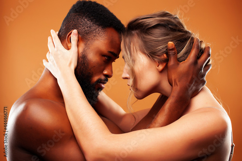 Young pretty couple diverse races together posing sensitive on brown background, lifestyle people concept