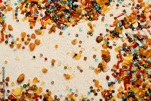 Stars falling. amber and beads on white sand background.