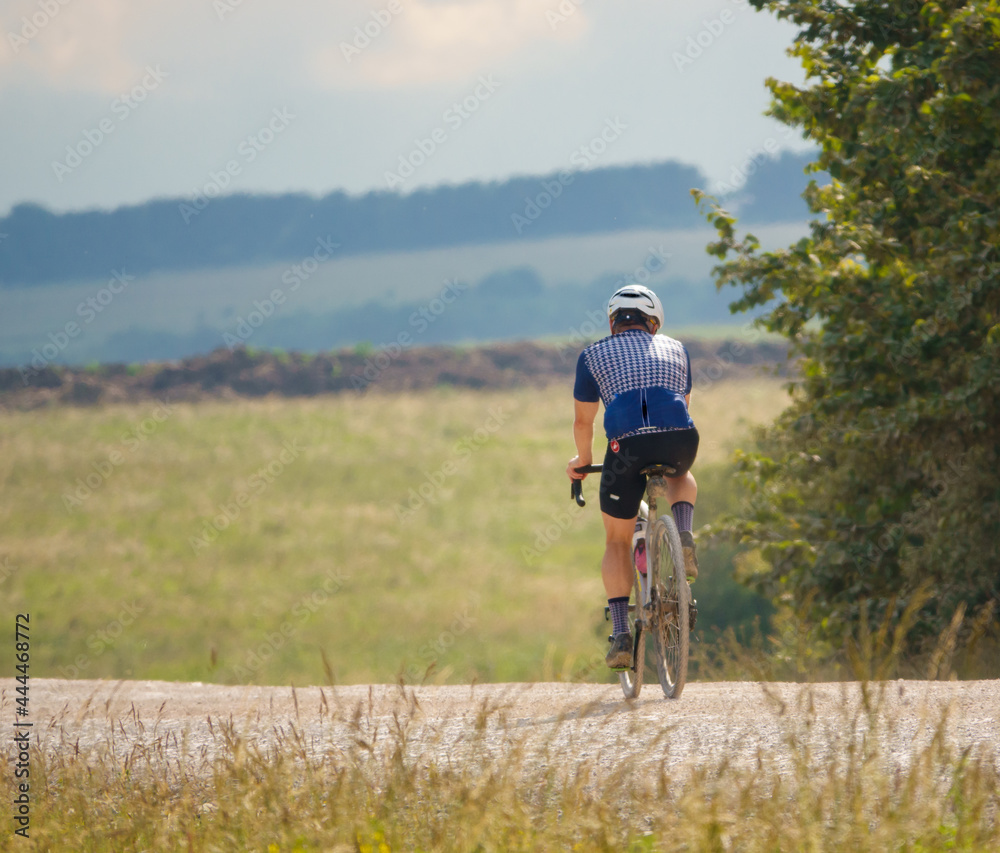 a sports cyclist on a stone track crossing salisbury plain, Wiltshire UK a sports cyclist on a stone track crossing salisbury plain, Wiltshire UK